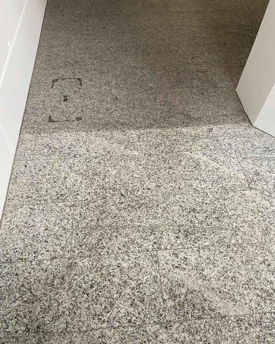 Granitboden in einem Gang, vorne gereinigt und hell, hinten noch grau verschmutzt